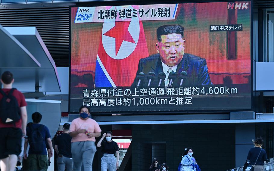 Pedestrians walk under a large video screen showing images of North Korea’s leader Kim Jong Un during a news update in Tokyo on Oct. 4, 2022, after North Korea launched a missile early in the day that prompted an evacuation alert when it flew over northeastern Japan. 