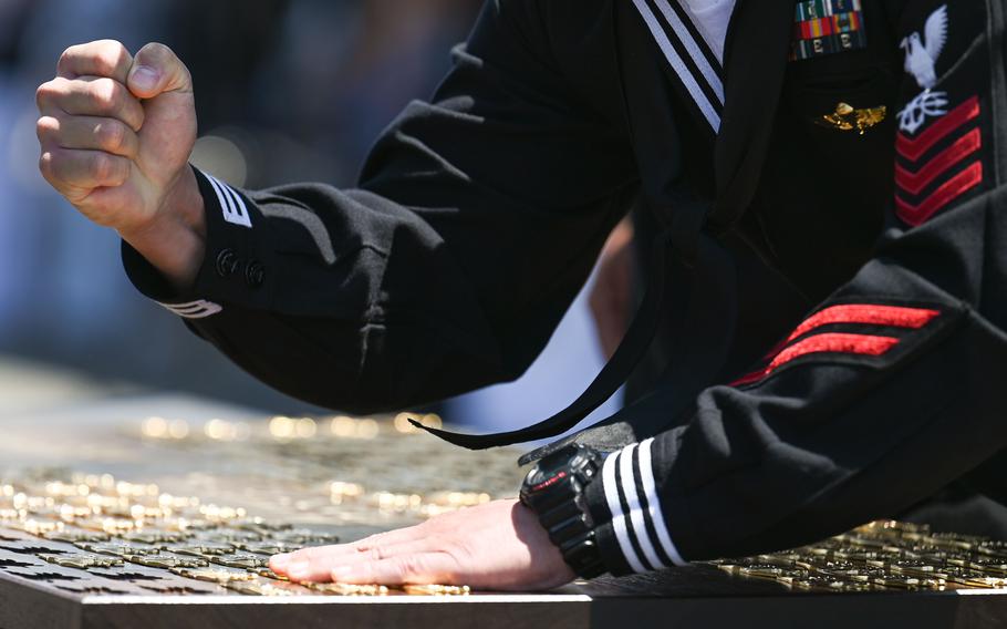 A Naval Special Warfare Operator stamps a trident onto a wooden plaque during a memorial service for Special Warfare Operator 1st Class Christopher Chambers and Special Warfare Operator 2nd Class Nathan Gage Ingram at Silver Strand Training Complex in Coronado, Calif., on Thursday, April 18, 2024. 