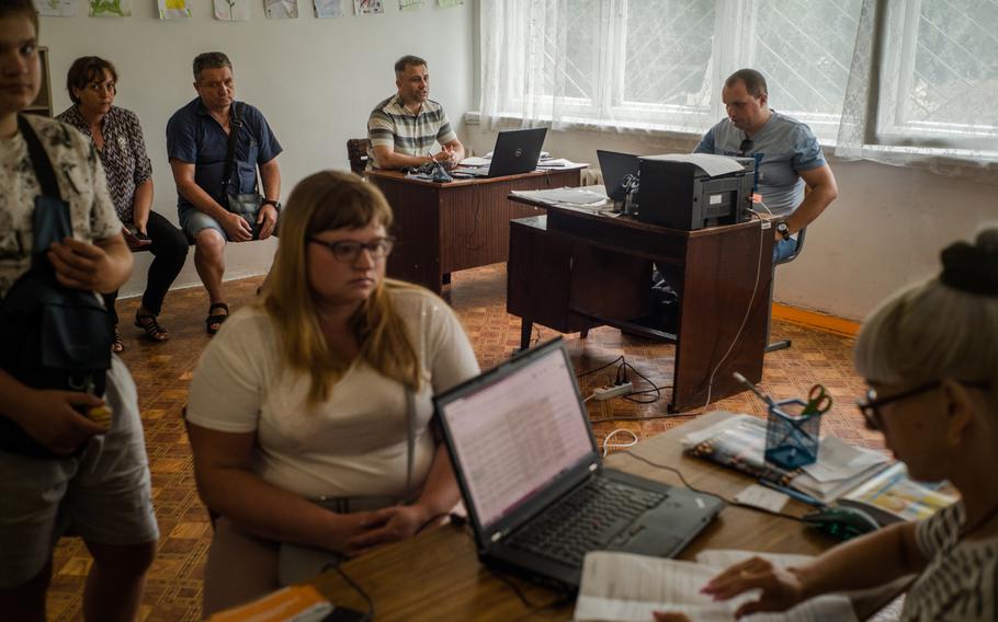 Mykola Khanatov, back corner, and other officials work in their remote headquarters in Novomoskovsk, Ukraine. 