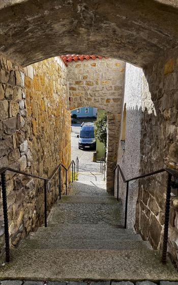 stone steps between walls lead to a street