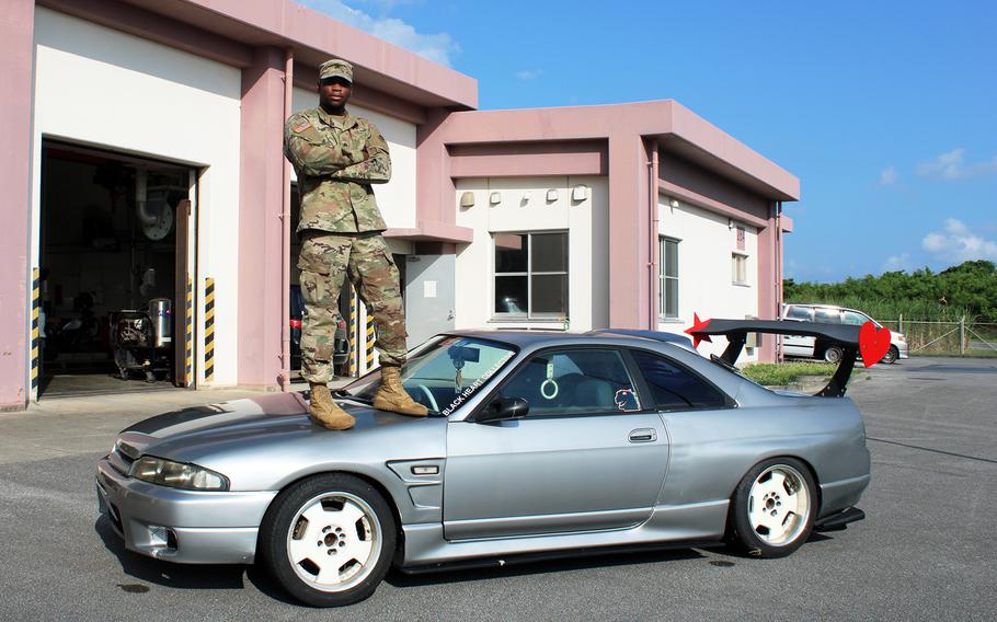 Army Sgt. Michael Dumpson, a 10th Support Group human resources specialist, poses atop his R33 Skyline at Torii Station, Okinawa, Sept. 23, 2021.