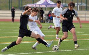 Ramstein’s Keiran Goodall gets a shot off between Stuttgart’s Christian Groves and Triston Milletich in the Royals 2-0 win over the Panthers in the Division I boys title game at the DODEA-Europe soccer championships in Ramstein, Germany, May 22, 2025. Ramstein took the title with a 2-0 win, with Goodall scoring the second goal..