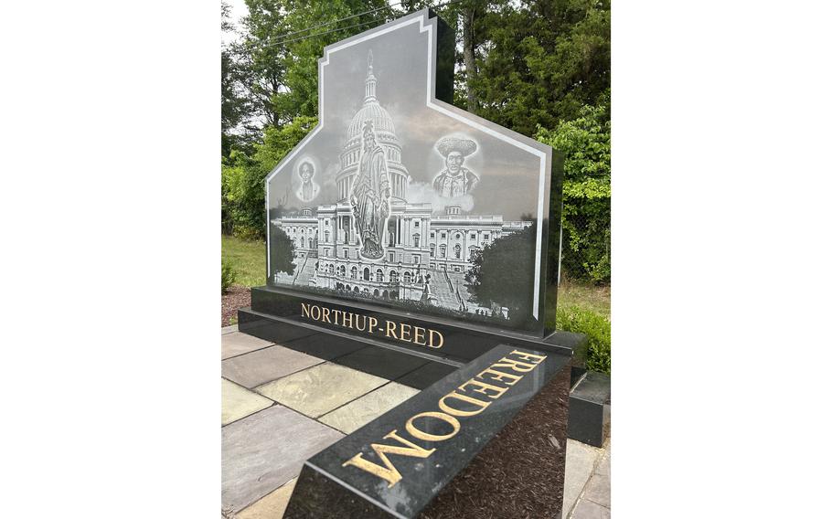 The monument to Solomon Northup and Philip Reed at National Harmony Memorial Park. There are no known images of Reed; the portrait on the right side comes from an 1881 engraving of an enslaved man in Washington.