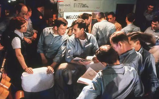 Former POWs talk during their flight from Hanoi to Clark Air Force Base (U.S. Air Force Photo)