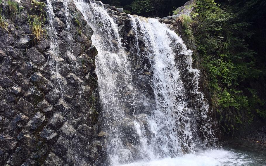 A waterfall over a dam on the river along the Tsutsuji Shindo Trail to Mount Hinokiboramaru is a summer destination of its own in Kanagawa prefecture, Japan.