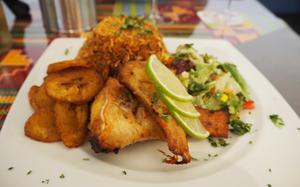 The grilled fish at Quagies in Kaiserslautern, Germany, comes with jollof rice and a side salad. Plantains can be added for 5 euros. 