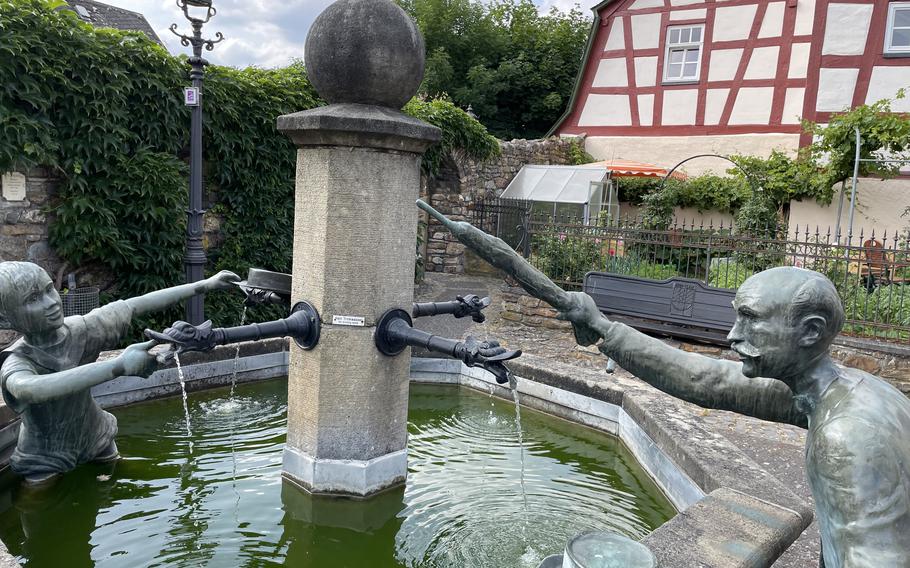 The Hankelbrunnen fountain, which portrays a boy appearing to splash a well-to-do man with water, adds to the charm of Herrstein, Germany.