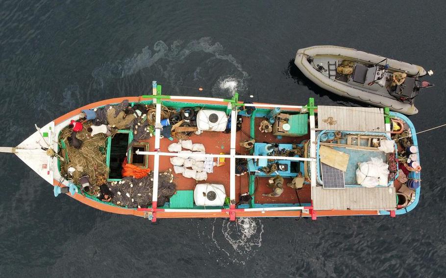 U.S. service members from coastal patrol ship USS Tempest and USS Typhoon inventory an illicit shipment of drugs while aboard a stateless dhow vessel transiting international waters in the Arabian Sea, Dec. 27, 2021. 