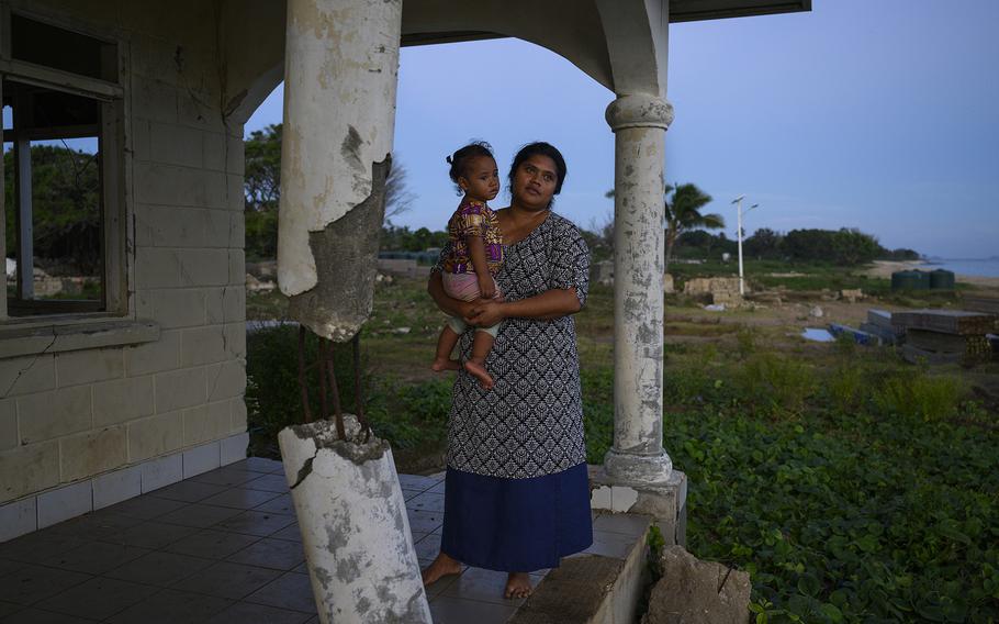 Sela Faitangane holds her daughter Nunia outside Nomuka's only hospital, which was destroyed by the tsunami. 