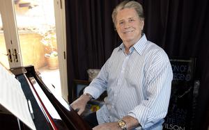 Wilson at the piano for a posed photo.