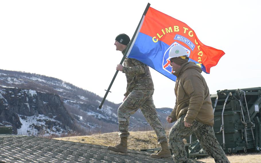 Army Col. Ryan Barnett, commander of the 3rd Brigade Combat Team, 10th Mountain Division, left, and Navy Lt. Mason Mullins, assigned to Naval Mobile Construction Battalion 11, cross a medium girder bridge laid down in support of Immediate Response 2024 in Bjerkvik, Norway, April 26, 2024.