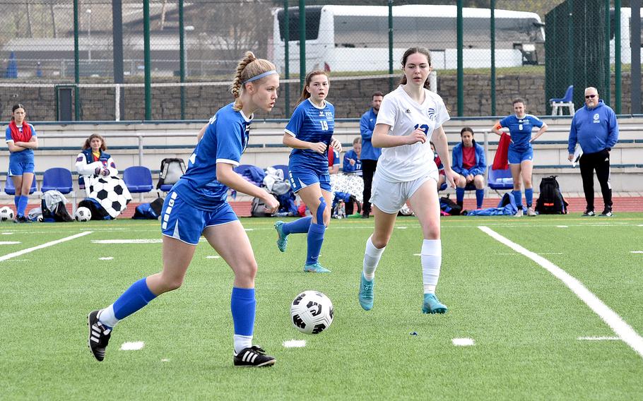 Ramstein's Taylor Laidlow dribbles as Wiesbaden's Bridget Pidgeon defends on Saturday morning at Ramstein High School on Ramstein Air Base, Germany. In the background, center, is the Royals' Kyndra Brown.