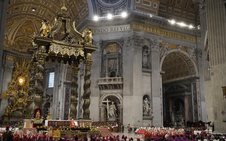 Cardinals, with white mitre hats, attend a final Mass inside St. Peter’s Basilica