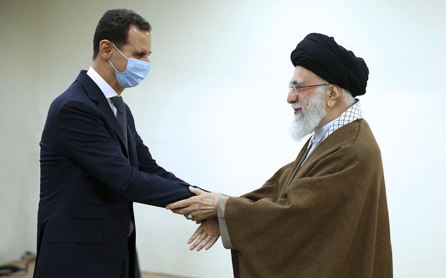 In this picture released by the official website of the office of the Iranian supreme leader, Supreme Leader Ayatollah Ali Khamenei, right, and Syrian President Bashar Assad shake hands at the start of their meeting, in Tehran, Iran, Sunday, May 8, 2022. Nour News, close to Iran’s security apparatus, said in the Sunday report that Assad met Khamenei and President Ebrahim Raisi earlier in the day.