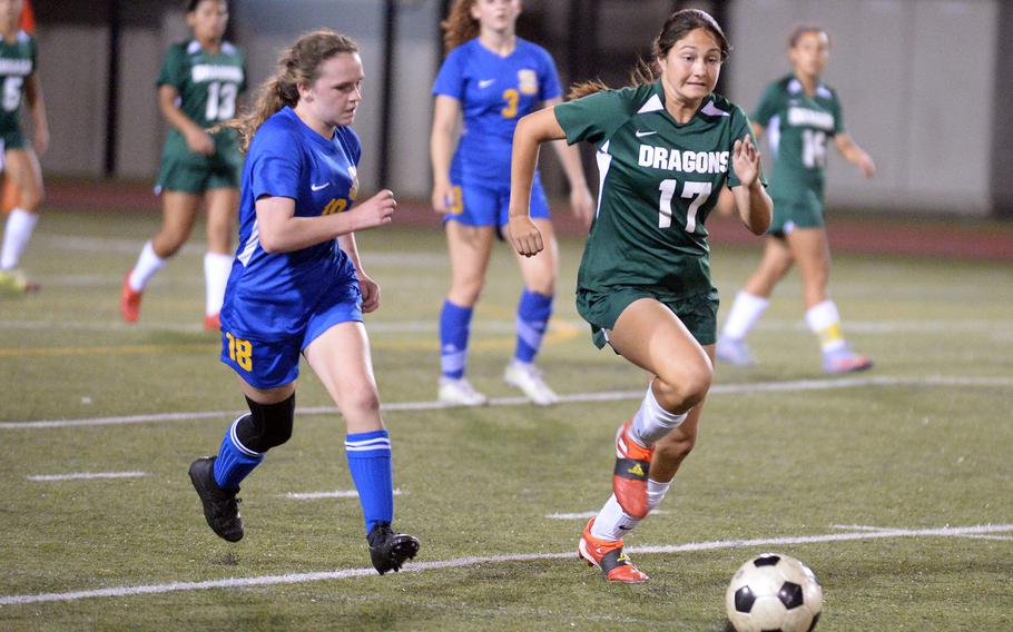 Yokota's Hailey Riddels and Kubasaki's Reighlyn Kissick chase the ball during Saturday's All-DODEA-Japan girls soccer tournament final. The Dragons won 4-1.