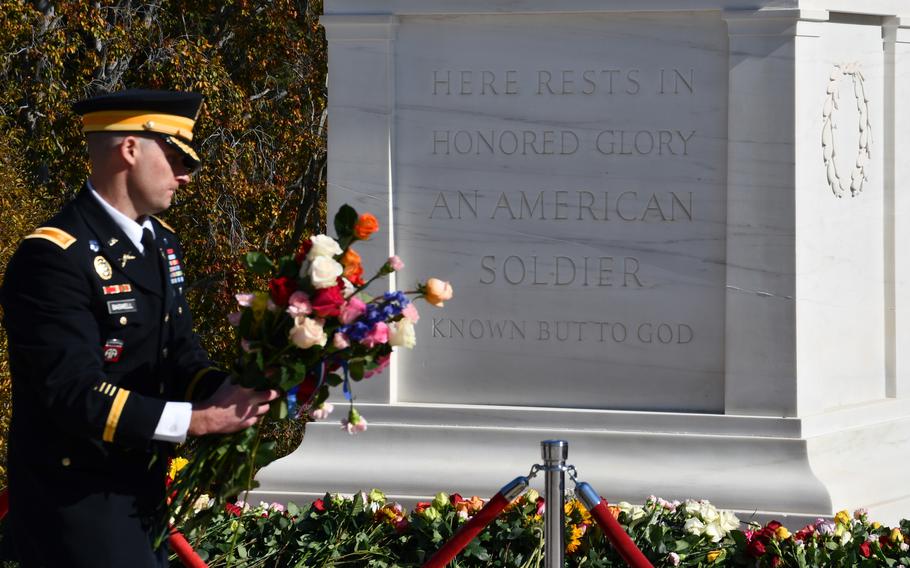 A soldier gathers flowers placed at the base of the Tomb of the Unkown Soldier on Wednesday, Nov. 10, 2021. A ceremony was held Tuesday and Wednesday to allow members of the public to approach the tomb and place flowers for the first time in recent history. 