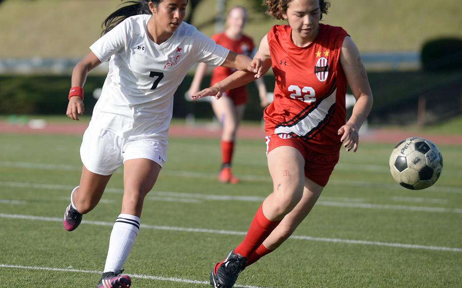 E.J. King's Fernanda Diaz and Nile C. Kinnick's Ren Sanders chase the ball during Friday's All-DODEA-Japan soccer tournament quarterfinal. The Red Devils downed the Cobras 3-1.