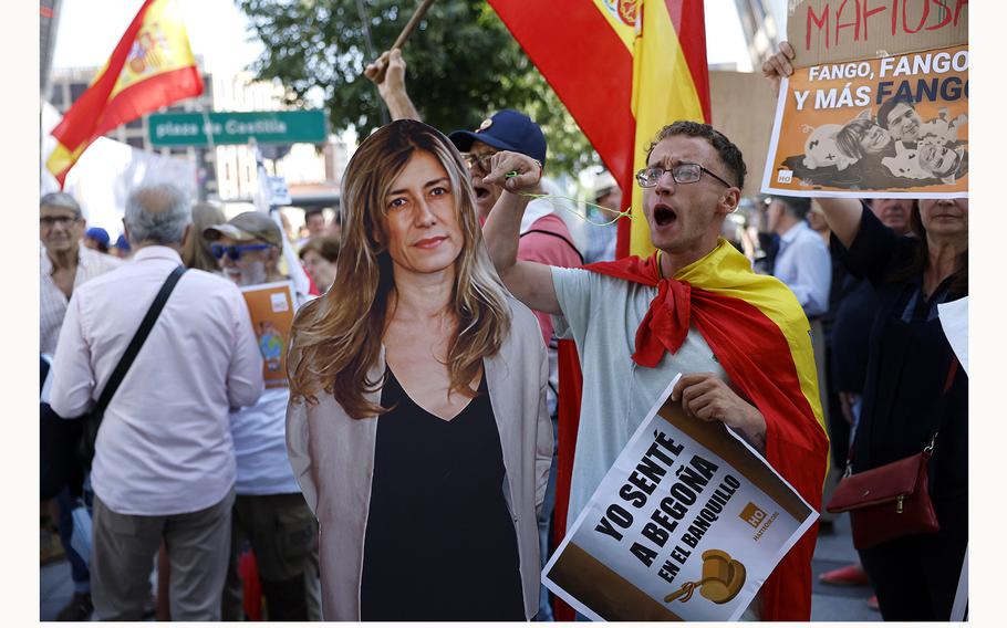 A protestor wrapped in a Spain’s flag gestures on July 4, 2024, next to an effigy of Begona Gomez, wife of Spain’s Prime Minister Pedro Sanchez, at Madrid Court, where Gomez is expected to appear before a magistrate in a graft probe.