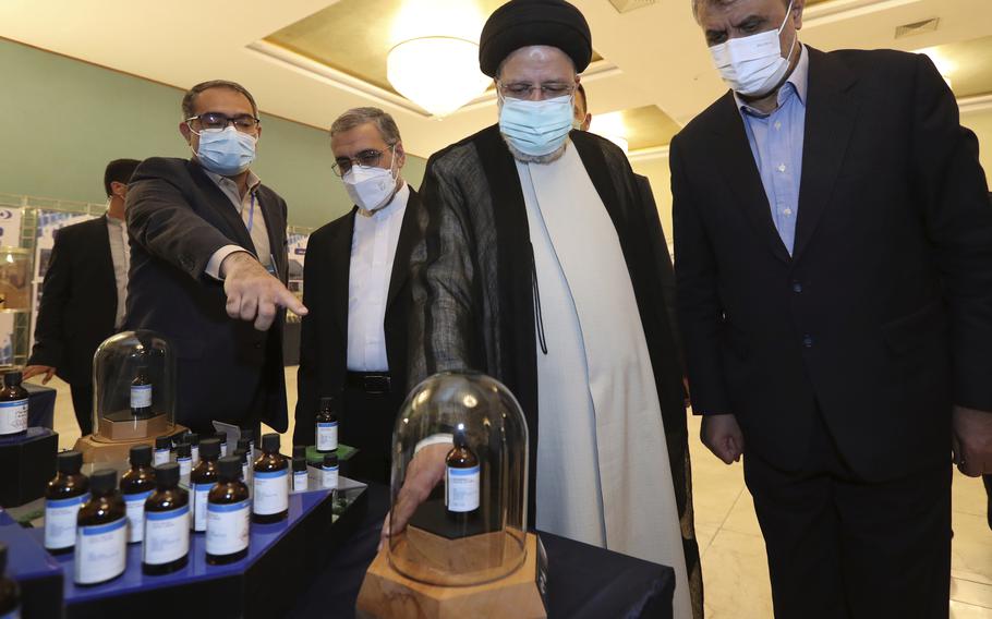 In this photo released by the official website of the office of the Iranian Presidency, President Ebrahim Raisi, second right, receives an explanation while visiting an exhibition of Iran's nuclear achievements in Tehran, Iran, Saturday, April 9, 2022. President Raisi said Saturday that Iran will continue nuclear activities as talks to revive Tehran's nuclear deal with world powers remain stalled.