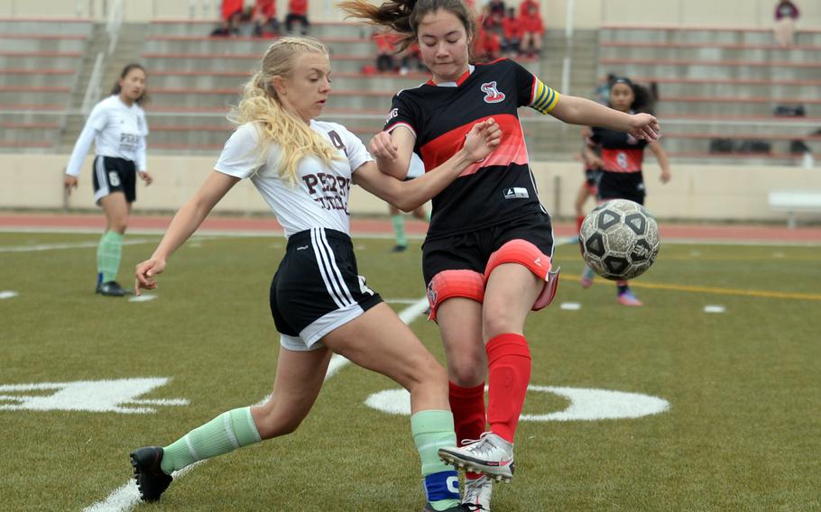 Matthew C. Perry's Cecilia Campbell and E.J. King's Aileen FitzGerald scuffle for the ball during Friday's DODEA-Japan girls soccer match. The Cobras won 3-0.