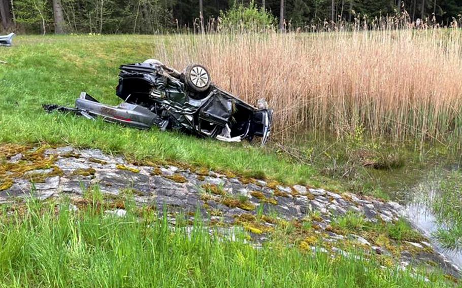 The totaled Volkswagen Jetta of a 23-year-old U.S. service member who was seriously injured in a car accident May 15, 2021, on the A9 autobahn near Bayreuth, Germany, lies on its roof near a drainage ditch.