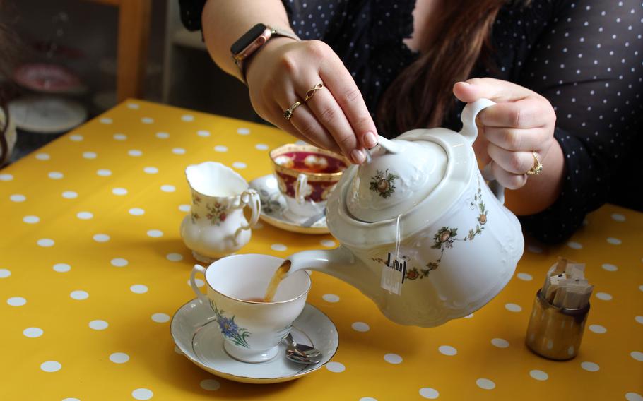 Kelly Alvarez serves a cup of breakfast tea just before our food platter arrives at Barleycorn in Mildenhall, England on May 24, 2021. Aside from English sandwiches and baked goods, the shop offers teas served in vintage china. 