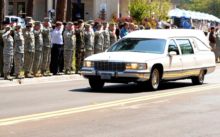 Team Hurlburt members from across the base line the streets, saluting the hearse carrying Senior Master Sgt. James Lackey as he is transported to the Hurlburt Field Airpark for his funeral April 16, 2010. 