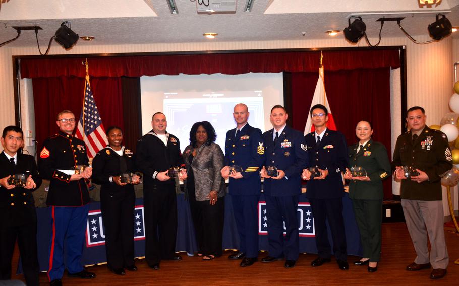 The winners of USO Japan’s 2022 Salute to Service Awards pose with USO area director Natalie Rowland at the Officers Club at Yokosuka Naval Base, Japan, on Nov. 10, 2022. From left: Petty Officer 3rd Class Hiroki Shirakura, Cpl. Michael Burdick, Petty Officer 1st Class Mionca Tomlinson, Petty Officer 2nd Class Christopher Payne, Rowland, Chief Petty Officer Daniel Nielson, Staff Sgt. Jarrod White, Master Sgt. Makoto Fujita, Master Sgt. Takako Sasaki and 1st Sgt. Guy Weaver