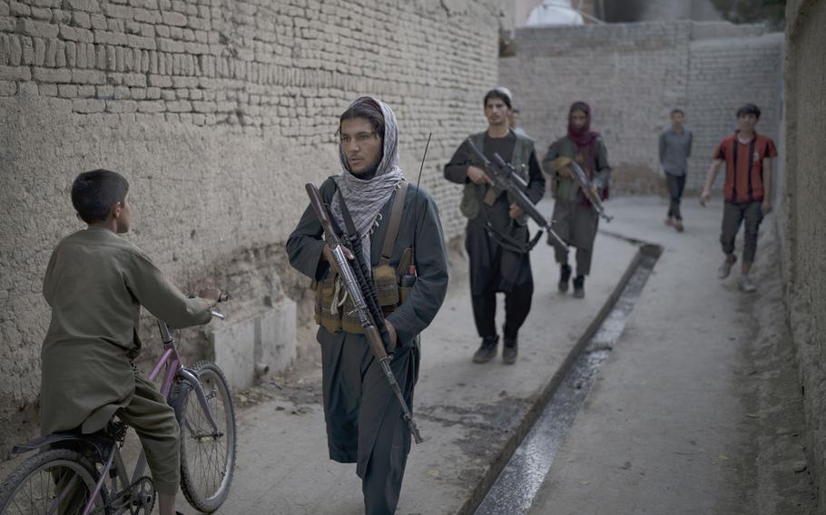 Taliban fighters patrol a neighborhood in search for a man accused in a stabbing incident, in Kabul, Afghanistan, Sunday, Sept. 12, 2021.