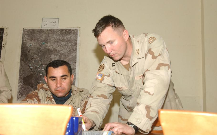 Then-Capt. Brian Mescall, of the 342nd Military Transition Team, standing, teaches a map-reading class to Iraqi army soldiers in Mosul on Feb. 13, 2006. 