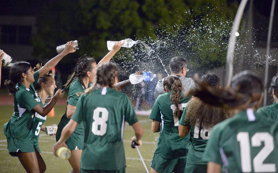 Kubasaki girls soccer coach Chris Eastman gets a victory shower from his players following Saturday's 4-1 win over Yokota in the All-DODEA-Japan tournament final.