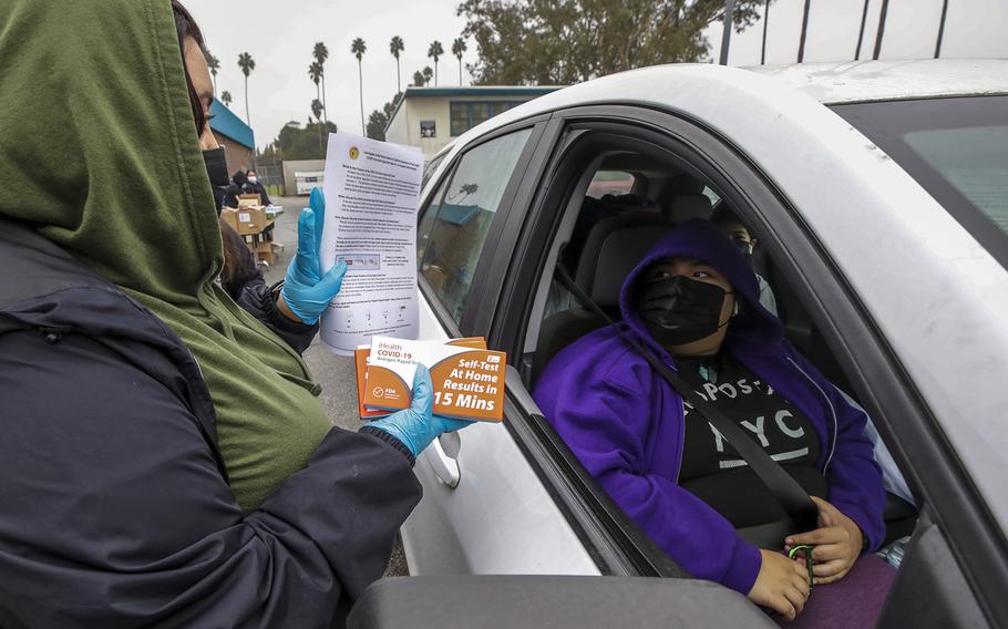 Wendy Lopez gives in-home COVID test kits provided by Los Angeles Unified School District free at Johnnie L. Cochran Jr. Middle School on Friday, Jan. 7, 2022, in Los Angeles, California.