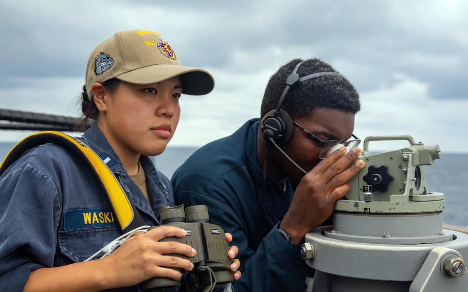 Lt. j.g. Chunchun Waskin and Seaman Samuel Figueroa Lopez scan the ocean's surface as the USS Barry passes through the Taiwan Strait, Friday, Sept. 17, 2021. 