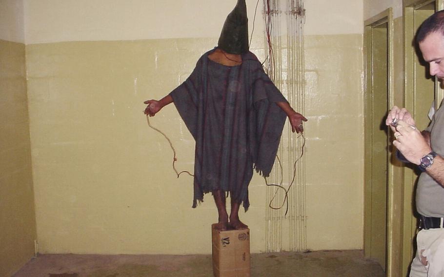 An unidentified detainee standing on a box is seen in late 2003 with a bag on his head and wires attached to him in the Abu Ghraib prison in Baghdad, Iraq. 