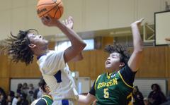 Yokota's Damian Abrams shoots against Robert D. Edgren's Axel Nogueras during Friday's 5th American School In Japan Kanto Classic boys knockout game. The Panthers won 53-24.