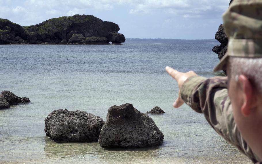 Army Maj. Robert Bourgeau points to the spot where he rescued three people from a riptide over the summer at Mermaid's Grotto in Onna, Okinawa, Oct. 3, 2022.