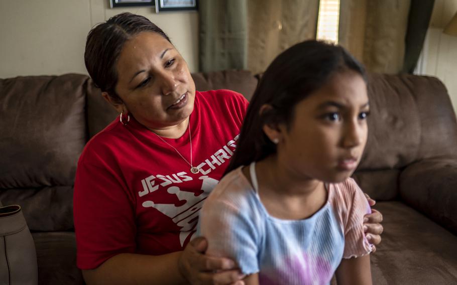 Marcela Cabralez straightens the hair of her granddaughter, Jalissa, at their home on Aug. 30, 2022 in Uvalde, Texas. Jalissa has struggled with nightmares in the months since the shooting, and she has expressed nervousness about going back to school.
