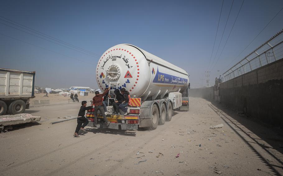 Palestinians wait for humanitarian aid trucks to enter the Gaza Strip through the Kerem Shalom crossing Saturday.