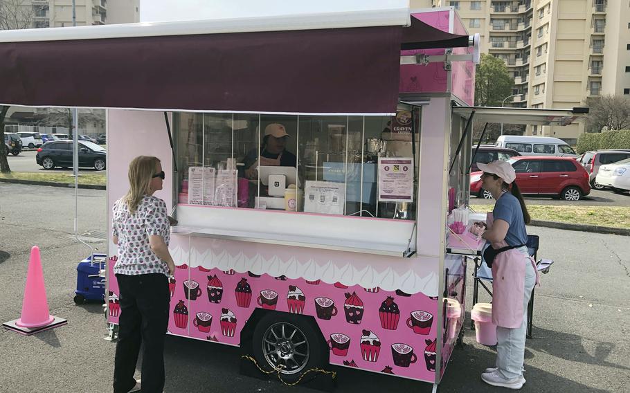 People stand outside a mobile food trailer.