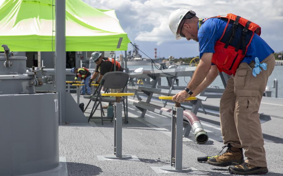 Workers open tank valves aboard a U.S. Navy fuel barge Oct. 28, 2022, while emptying fuel from pipelines connected to the Red Hill Bulk Fuel Storage Facility, Hawaii.