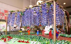 Akira Iwabuchi's work at the Tokyo Origami Museum, "Under the full-blown wisteria trellis of cranes!!," features small origami cranes displayed in such a way to resemble a wisteria trellis and grass. 