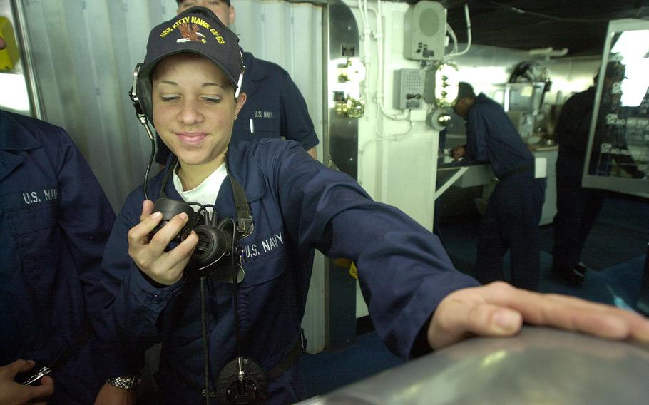 Seaman Natalia Francisquini Gines stays in touch with the engineering spaces through a sound-powered phone while standing watch on the bridge of the USS Kitty Hawk on Monday, April 15, 2002.