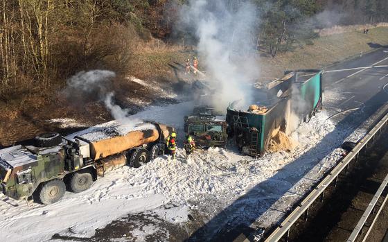 Firefighters work to extinguish a fire that broke out after a civilian truck rammed parked U.S.-military fuel trucks on the A3 autobahn near Parsberg, Germany, on Dec. 20, 2021. The driver of the commercial semitrailer died and U.S.-personnel are currently under investigation for negligent homicide.  