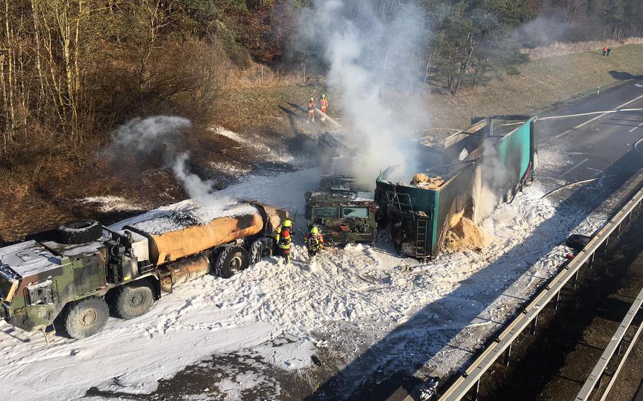 Firefighters work to extinguish a fire that broke out after a civilian truck rammed parked U.S.-military fuel trucks on the A3 autobahn near Parsberg, Germany, on Dec. 20, 2021. 