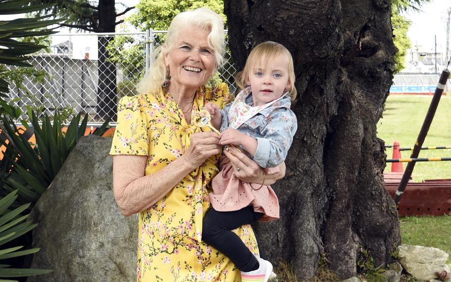 Becky Armstrong, left, and Adeline Armstrong, relatives of former Yokota commander Col. Fred Stevers, pose under the Japanese American Community Relations Tree on the air base in western Tokyo, April 23, 2023.