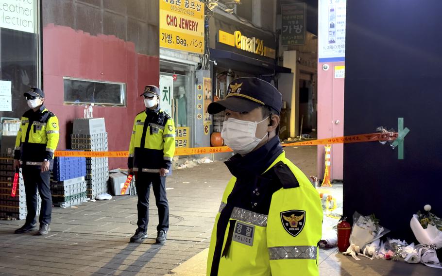 South Korean police guard the entrance to an alleyway where some of over 150 victims were killed after a crowd of people were crushed during Halloween festivities in Itaewon, South Korea, Oct. 31, 2022 . 