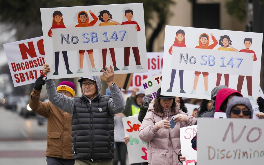 Demonstrators march in opposition to Texas Senate Bills 147 and 552 on Sunday, Jan. 29, 2023, in Dallas. SB147 would outlaw real estate/property ownership by citizens from four countries: China, Iran, North Korea and Russia.