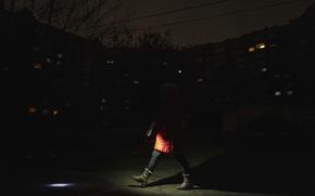 A woman lights up the road with a flashlight during blackout in Kyiv, Ukraine, Friday, Feb. 3, 2023. 