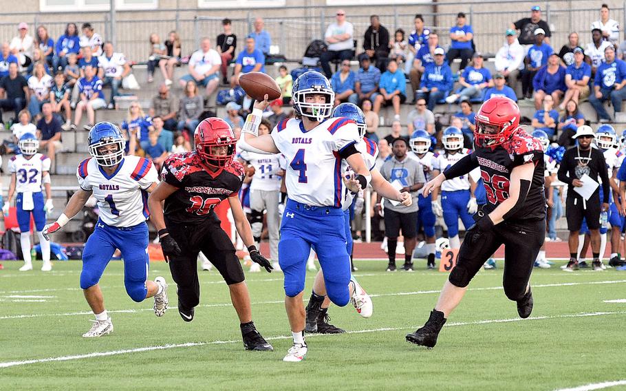 Ramstein quarterback Lucas Hollenbeck throws during a first-quarter play of the Royals' matchup with Kaiserslautern on Sept. 15, 2023, at Babers Stadium in Kaiserslautern, Germany. Chasing are, from left, Raider linebacker Manu Smolinski and defensive lineman Sherman Wickings.