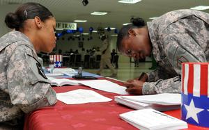 U.S. Army Pfc. Chyna Williams, from Crestview, Fla., assists Staff Sgt. Janeen Butler, from Seabrook, Md., complete an absentee ballot at Camp As Sayliyah, Qatar, Oct. 16, 2008. The last-minute voting assistance drive at the U.S. military installation was an effort to help deployed service members send their ballots in time for local and general elections. "This is convenient," said Butler, "I started the process on the Internet and finished it here, today." Each voter was provided a tracking identification number for their absentee ballot.